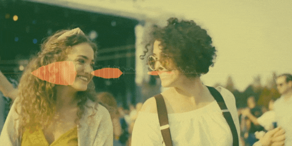 Two young women dancing among the crowd at a festival